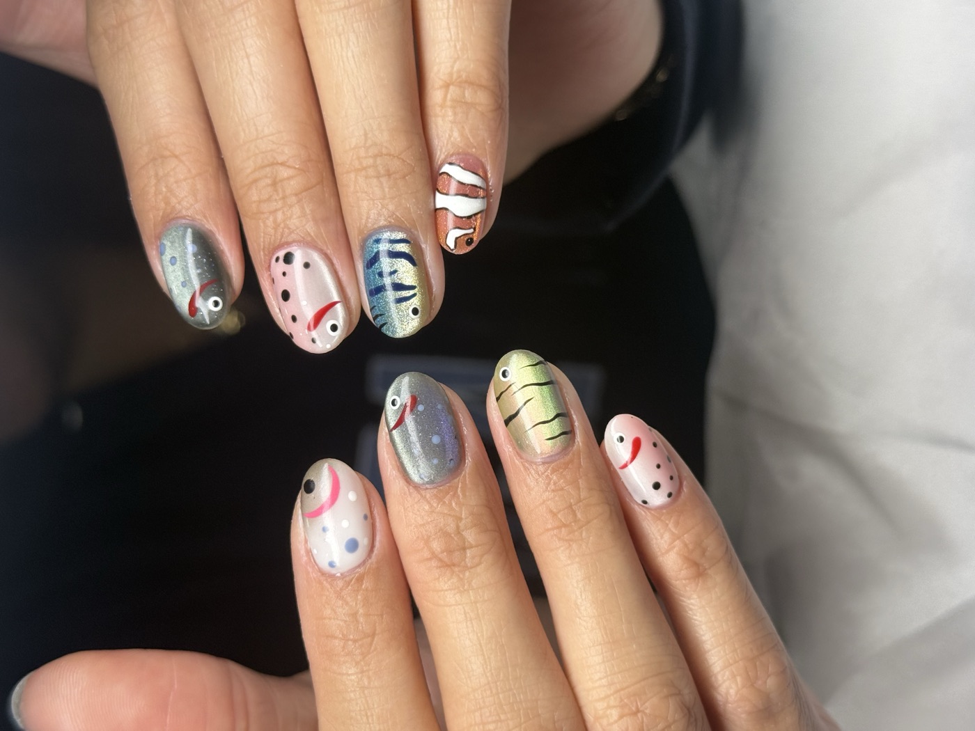 Short round nails with playful hand-painted fish and seafood character art