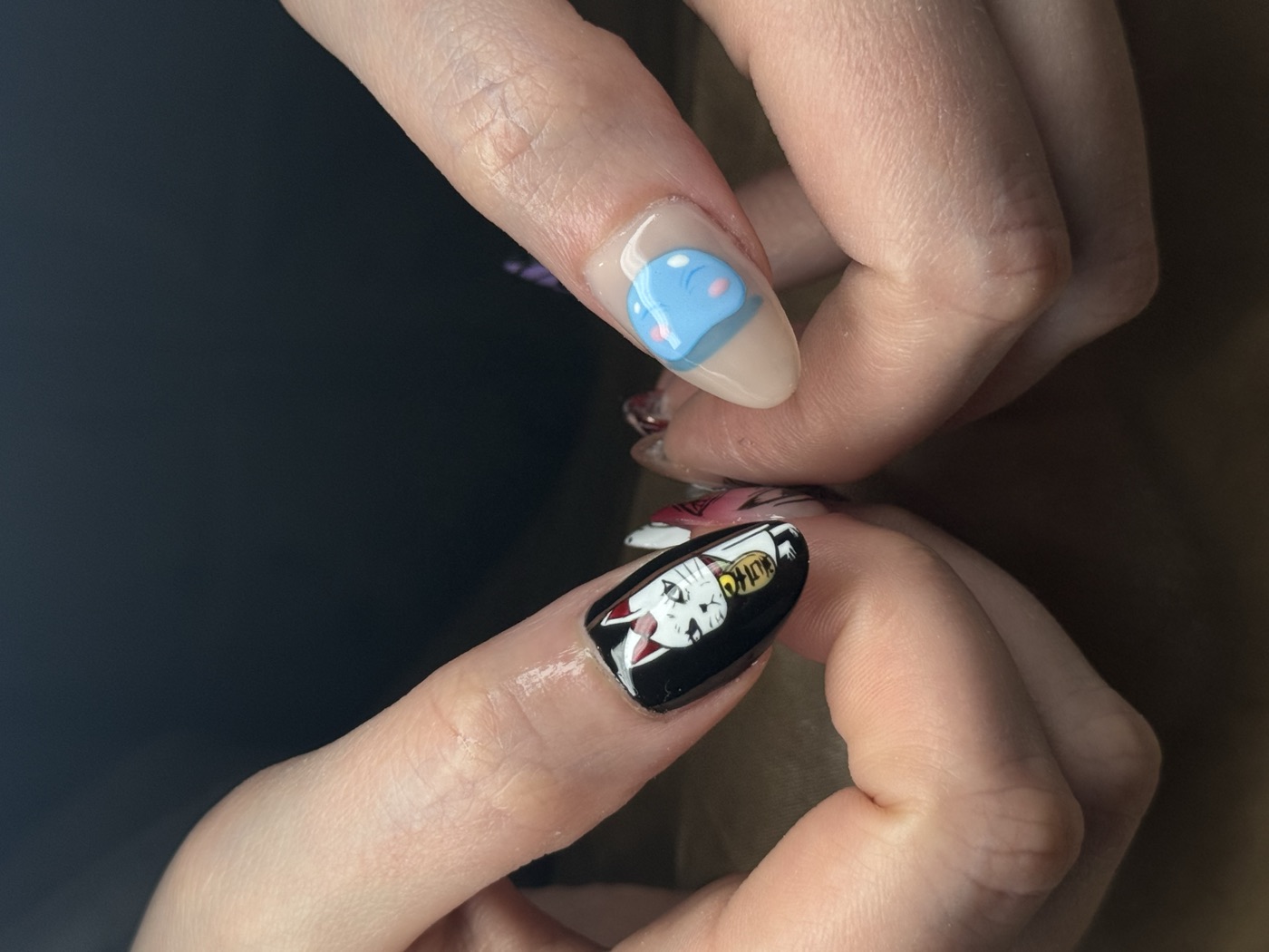 Short almond nails with hand-painted lucky cat and pastel character art